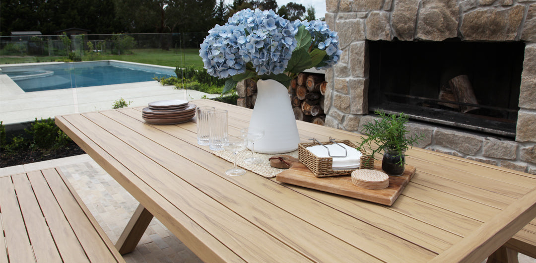 Timber-look outdoor table and bench dining setting on a patio