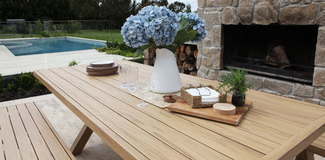 Timber-look outdoor table and bench dining setting on a patio