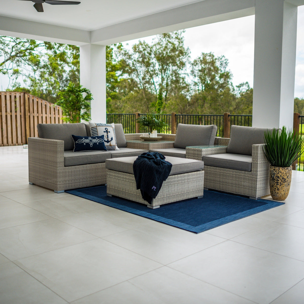 Modular outdoor lounge setting arranged in a corner layout with a coffee table