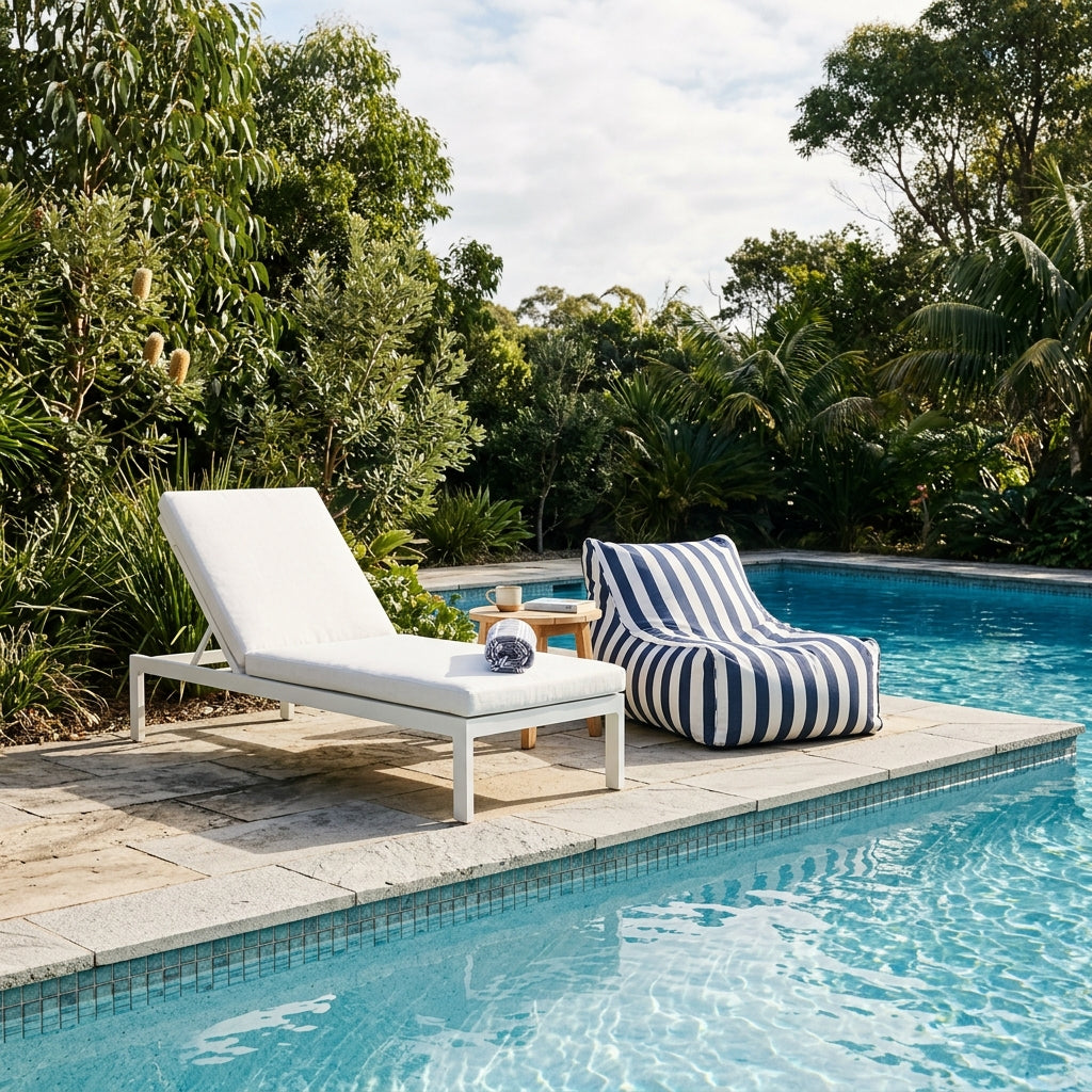 Sun lounge and striped bean bag beside a pool